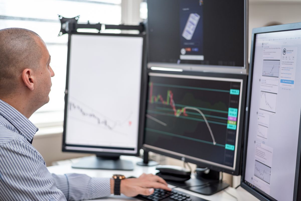 A professional examining market charts at a research workstation